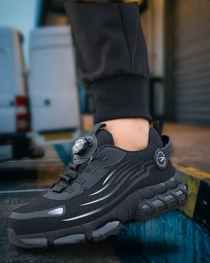 Zapatilla WorkArmor negra en un muelle de carga, con una furgoneta detrás