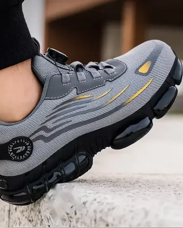 Pie calzado con la zapatilla gris pisando un bordillo de hormigón